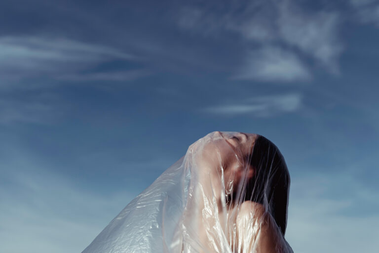 Woman In Nature Covered With Plastic